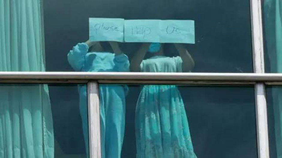 Migrantes aislados en un hotel piden ayuda a través de las ventanas tras ser deportados de EU a Panamá